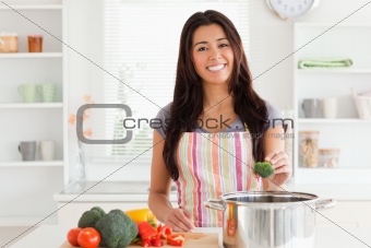 Beautiful woman preparing vegetables while standing