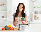 Gorgeous female preparing vegetables while standing