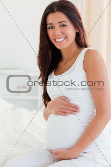 Portrait of a good looking pregnant woman touching her belly