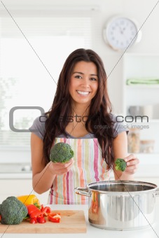 Attractive female preparing vegetables while standing