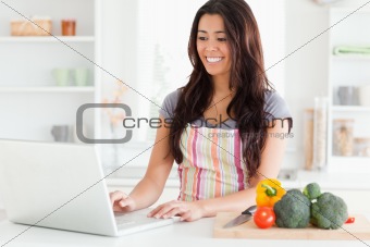 Gorgeous woman relaxing with her laptop while standing