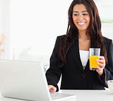 Pretty woman in suit relaxing with her laptop while holding a