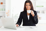 Gorgeous woman in suit enjoying a cup of coffee while relaxing 