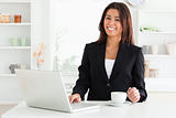 Attractive woman in suit enjoying a cup of coffee while relaxing