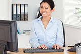 Attractive woman typing on a keyboard while sitting