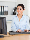 Gorgeous woman typing on a keyboard while sitting