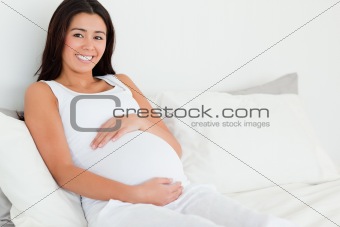 Frontal view of a beautiful pregnant woman touching her belly