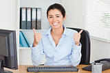Proud attractive woman with thumbs up posing while sitting