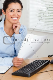 Beautiful woman posing while holding a sheet of paper