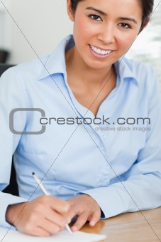 Frontal view of a beautiful woman writing on a sheet of paper