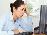 Attractive upset woman looking at a computer screen while sitting