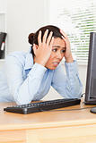 Charming upset woman looking at a computer screen while sitting