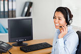 Good looking woman wearing a headset and discussing while sitting