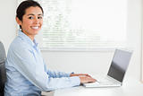 Attractive woman working with her laptop and posing while sitting