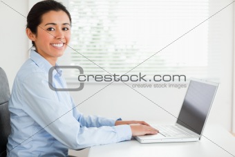 Attractive woman working with her laptop and posing while sitting