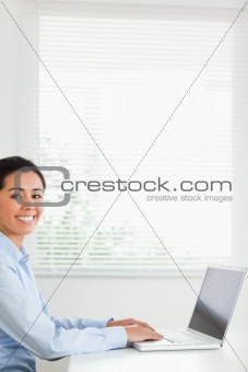 Beautiful woman working with her laptop and posing while sitting