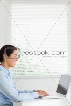 Beautiful woman working with her laptop and typing while sitting