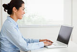 Attractive woman working with her laptop and typing while sitting