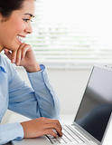 Good looking woman working with her laptop and typing while sitting