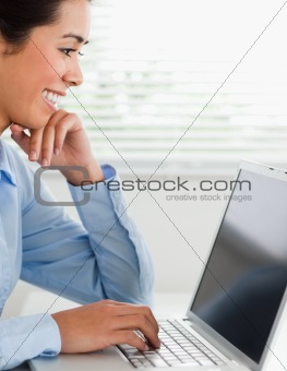 Good looking woman working with her laptop and typing while sitting