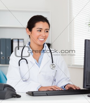 Beautiful woman doctor typing on a keyboard