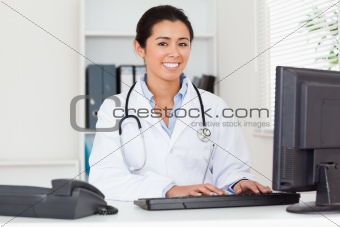 Good looking woman doctor typing on a keyboard