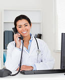 Good looking woman doctor on the phone while sitting