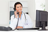 Attractive woman doctor on the phone while sitting