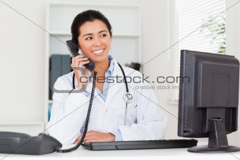 Attractive woman doctor on the phone while sitting