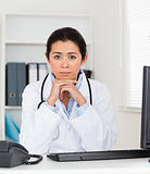 Beautiful worried woman doctor looking at the camera while sitting