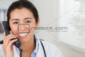 Lovely female doctor on the phone and posing