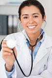 Good looking female doctor using a stethoscope while looking 