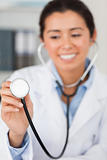 Gorgeous female doctor using a stethoscope while looking