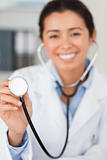 Lovely female doctor using a stethoscope while looking 