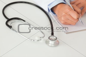 Female doctor writing on a scratchpad