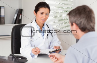 Patient giving his beautiful woman doctor a piece of paper