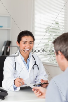 Patient giving his good looking woman doctor a piece of paper