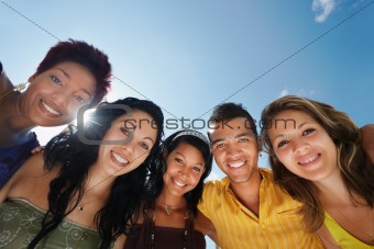 team of man and women embracing, smiling at camera