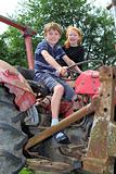 Two children playing on an old tractor