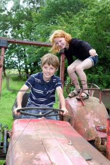 Two children playing on an old tractor