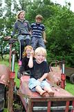 Four children playing on an old tractor