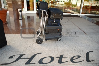 Suitcases and trolley in front of hotel