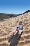 Boy sitting on sand dune in Egypt