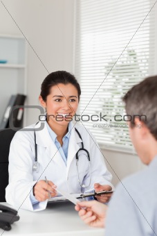 Patient giving his pretty woman doctor a piece of paper