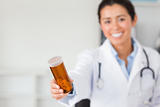 Gorgeous smiling doctor holding a box of pills