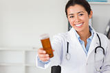 Pretty smiling doctor holding a box of pills