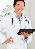 Beautiful female doctor with a stethoscope holding a notebook 