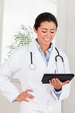 Attractive female doctor with a stethoscope holding a notebook 