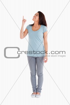 Pretty woman showing a copy space with her finger while standing