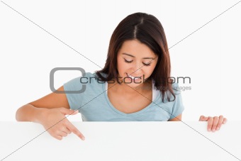 Portrait of a beautiful woman pointing at a board